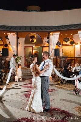 A radiant bride and her dad doing their father/daughter dance.