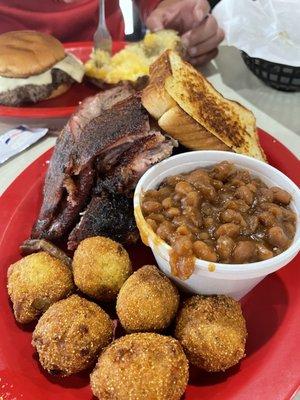 Ribs (good) and sliced brisket (bad) with sweet baked bean (good) and jalapeño hush puppies (bad).