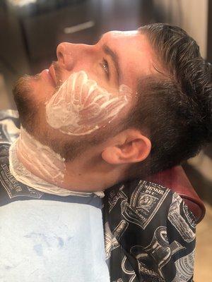 Tristan is receiving a beard line up with his Haircut/Beard Trim service, complete with hot towels and hot lather shave.