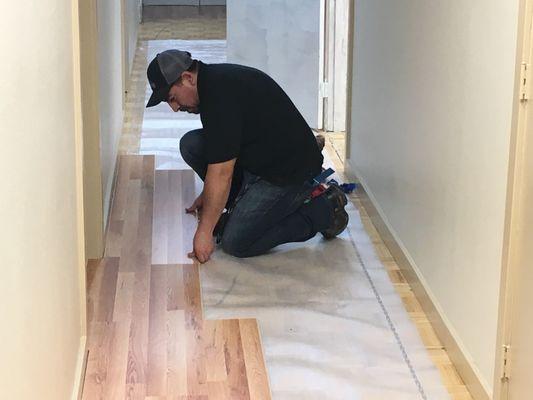 Workers installing laminate flooring.