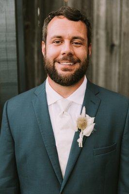 Handsome groom with his dried floral boutonniere on a magnetic clip