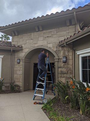 Sean installing a security camera in the pool area for an apartment complex.