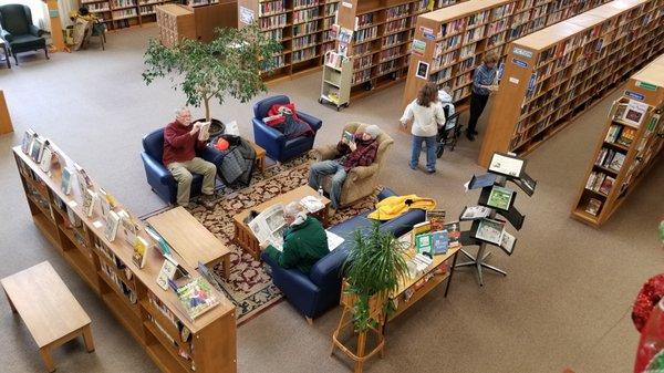 Comfortable seating with tall ceilings and a view to the second level.