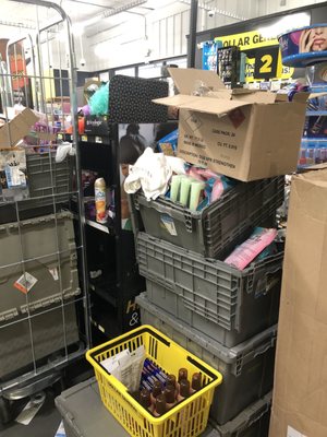 More crates/boxes with inventory needing to be shelved and placed near the front of the store