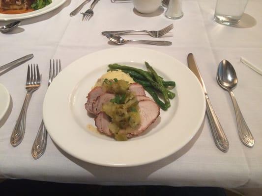 Pork tenderloin with an apple chutney rested on mashed potatoes with green beans and asparagus