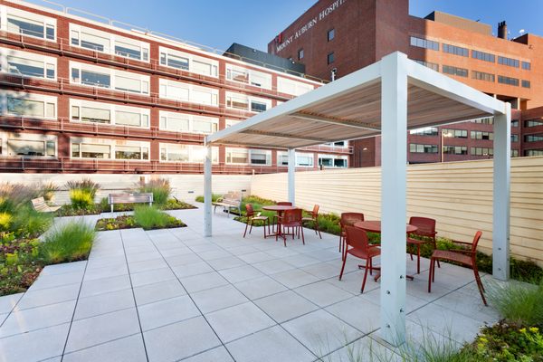 A combination of painted aluminum and cedar slat roof panels creates a stunning profile for this modern pergola.