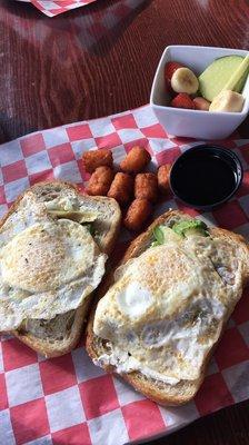 Goat cheese avocado toast with sweet potato tots and fruit salad.