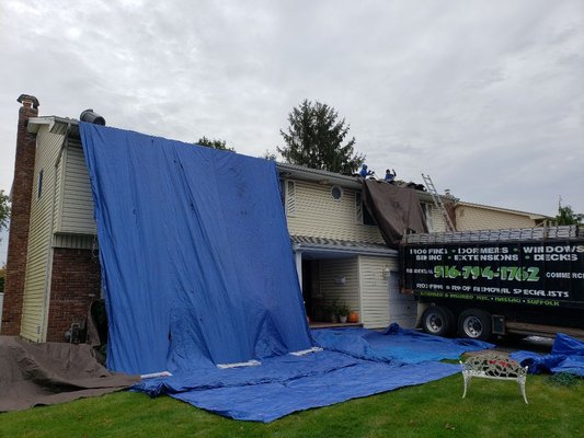 The house and grounds are being protected with tarps. On this job 99% of the old roofing went directly into the truck.