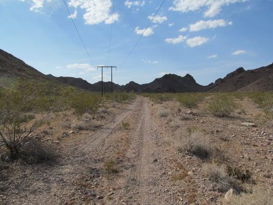 The power line road is uphill on the way to the forest.