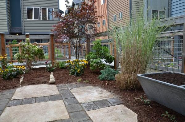 Custom built patio using salvaged sandstone and pavers. A salvaged concrete sink was turned into a raised planter.