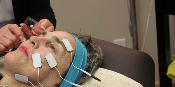 Vibha customer getting a Microcurrent Facial treatment, facial pads reduces the deep wrinkles naturally