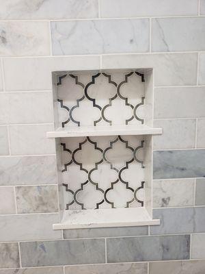 Custom niche with polished marble design and quartz custom shelves by Juan Valadez and Martin.