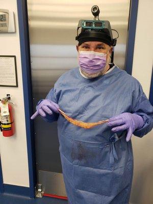 Dr. Zimmerman holding the excess skin he removed off a female patient during surgery.