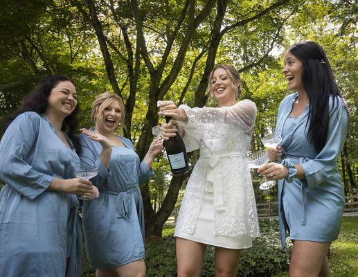 Bride opening Champagne with her her brides maids