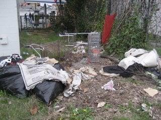 piles of trash left sitting in front of this neighborhood dump