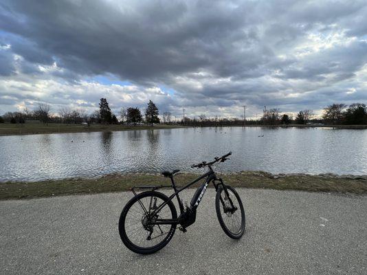 Black Trek E-Bike with water in the background on dusk filled sky.