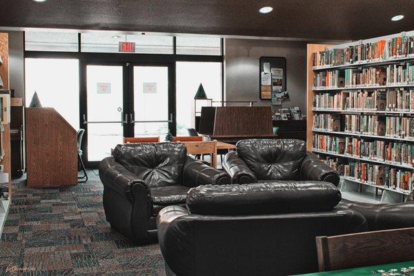 Reading area and comfy chairs, with personal desks (plus outlets) in the background.