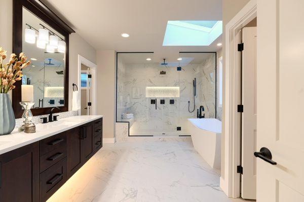 Premium bathroom remodel. Espresso vanity cabinets, sleek matte black fixtures, and breathtaking marble tile throughout.