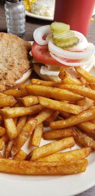 Pork tenderloin sandwich with seasoned fries.