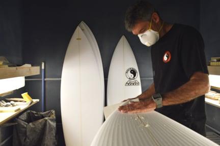 T&C Surfboard shaper Makani McDonald inspects a cut blank before shaping the board.