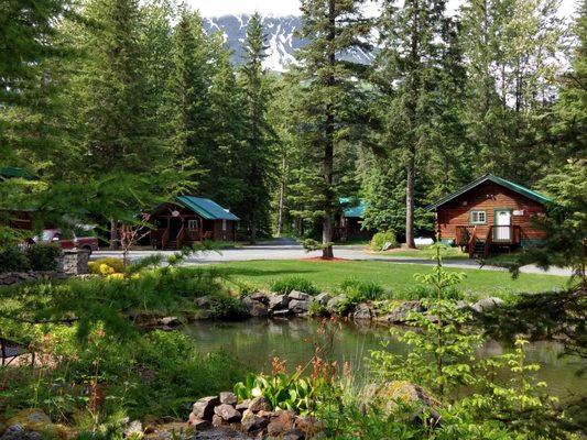 Box Canyon Cabins is nestled among lush green spruce trees and surrounded by towering snow-capped mountains.