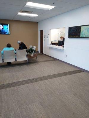 Another view of the spacious waiting area with a TV.