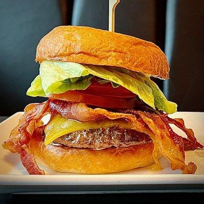 We top our 6 oz. charbroiled burger with melted cheddar cheese and thick slices of Hormel smokehouse bacon, lettuce, pickles, tomato and sav