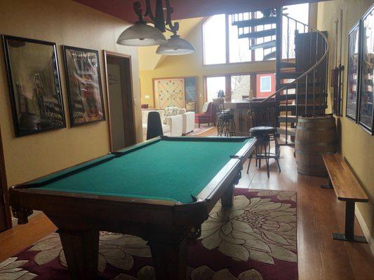 Pool table with the loft leading up the spiral stairs case