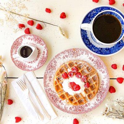 Chai Spice Waffle with homemade whipped cream, raspberry compote, and fresh raspberries, served with real NY Maple Syrup