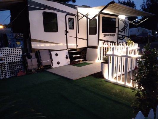 Inexpensive indoor/outdoor carpet and fencing from Lowes held in place by large planters make for a wonderful outdoor living space.