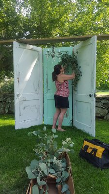 Adding florals to the arbor backdrop.