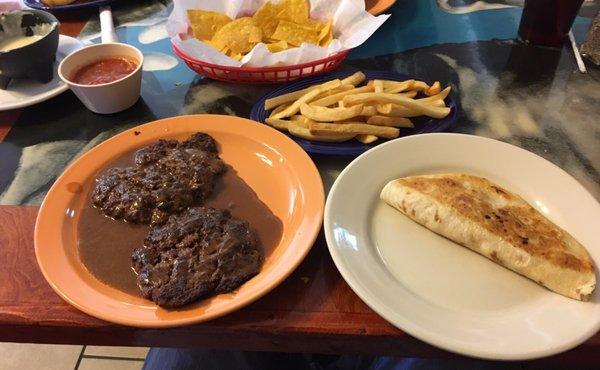 Hamburger steak, fries, and a quesadilla.