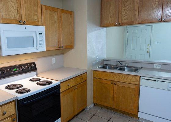 sink side of kitchen with bar and dishwasher in 2/2