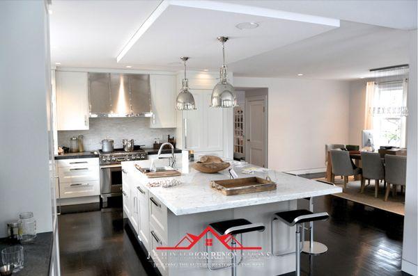 Open concept kitchen white shaker cabinetry 
 , massive island with fridge panels.