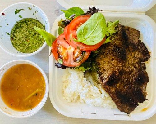 Skirt steak with chimichurri and a side of salad, white rice and beans