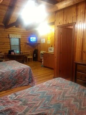 Inside cabin 2 (two queen sized beds, TV w/basic channels, full bathroom, kitchen w/stove top, mini-fridge, microwave & sink)