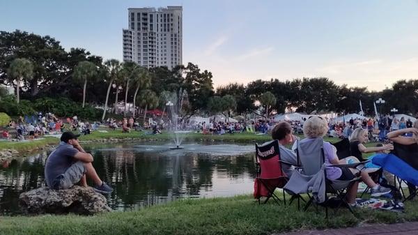 Audience relaxing around the pond