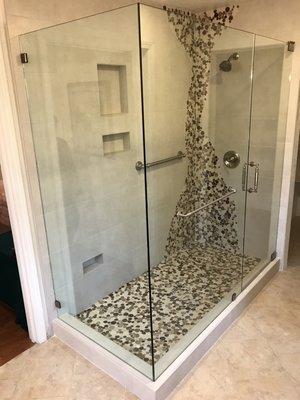 Porcelain tile shower with flat river rock in custom design to homeowners specs.