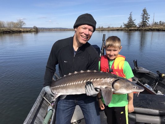 Father and son sturgeon fishing on Snohomish river.