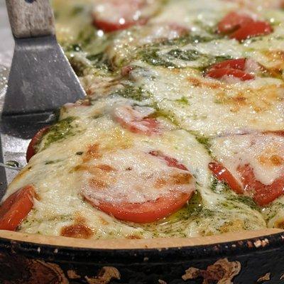 El Blanco deep dish pizza with pesto, white sauce, tomatoes and cheese