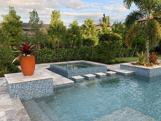 Infinity Style spa with glass tile and stepping columns