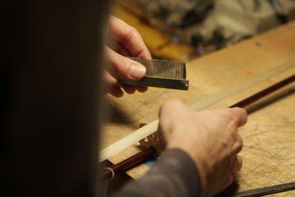 Combing the hair of a violin bow