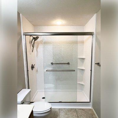 This bright and open walk-in shower design is in style "Alabaster White" in pattern "Random Stone."