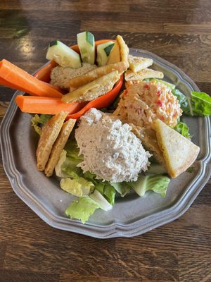 The Trifecta, with chicken salad l, Pimento cheese, and fresh hummus on a bed of romaine with toasted pita points