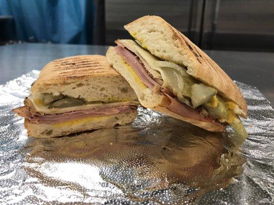 Notorious P.I.G: Slow Roasted Pork Tenderloin, Honey Baked Ham, Swiss Cheese, Pickles, and Yellow Mustard. Served on a grilled Panini Roll.