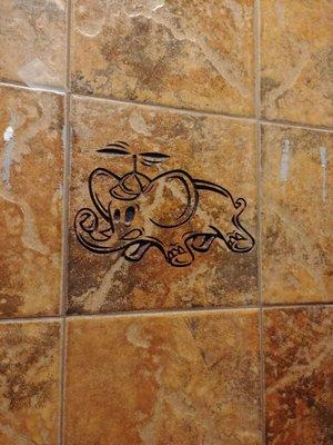 Carved into the bathroom tile!