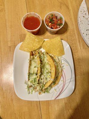 Two grilled chicken tacos from my order of 3, salsa and Pico De Gallo with homemade chips