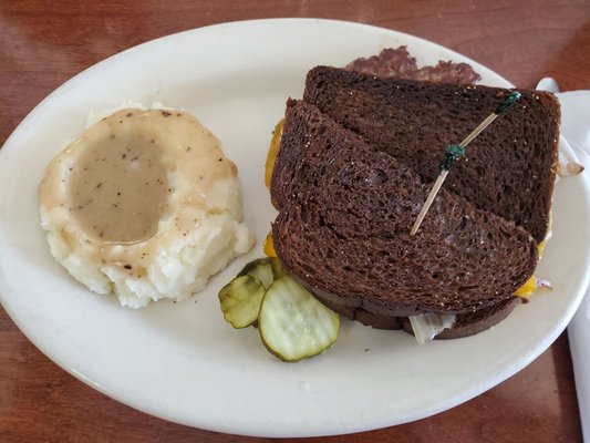 Patty Melt on Reuben with a side of mashed potatoes and gravy