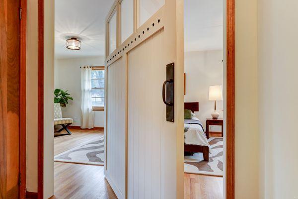 Love the repurposed carriage door made to pivot for the entry to the oversized master bedroom