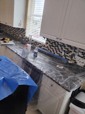 Removing kitchen tiles and replacing them with new grey and white tiles